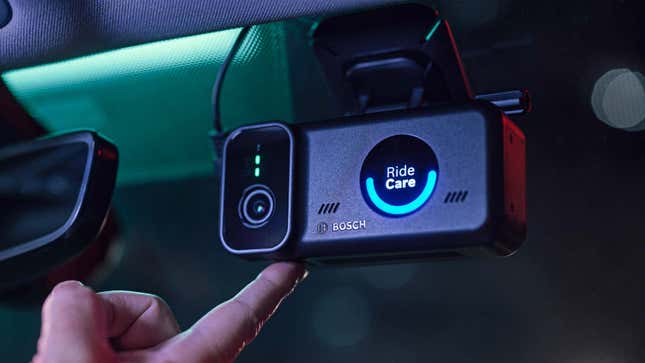A driver pressing a button on the windshield mounted Bosch RideCare dashcam.