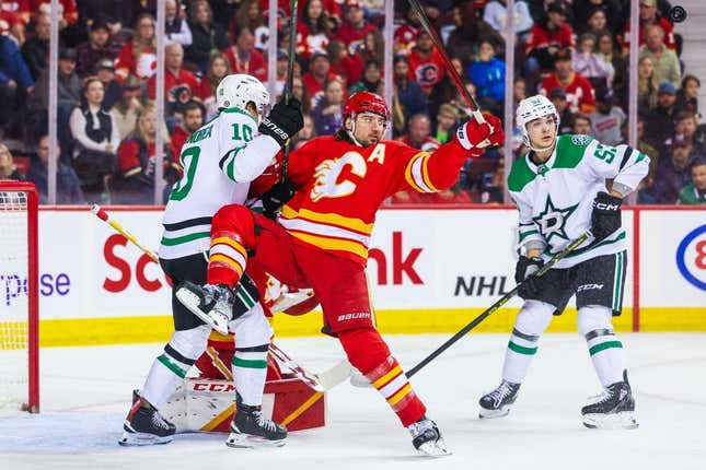 Mar 18, 2023; Calgary, Alberta, CAN; Calgary Flames defenseman Chris Tanev (8) and Dallas Stars center Ty Dellandrea (10) battle for the puck in front of Calgary Flames goaltender Jacob Markstrom (25) during the first period at Scotiabank Saddledome.