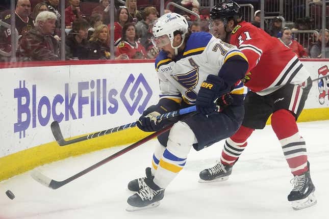 Mar 30, 2023; Chicago, Illinois, USA; St. Louis Blues defenseman Justin Faulk (72) and Chicago Blackhawks right wing Taylor Raddysh (11) go for the puck during the first period at United Center.