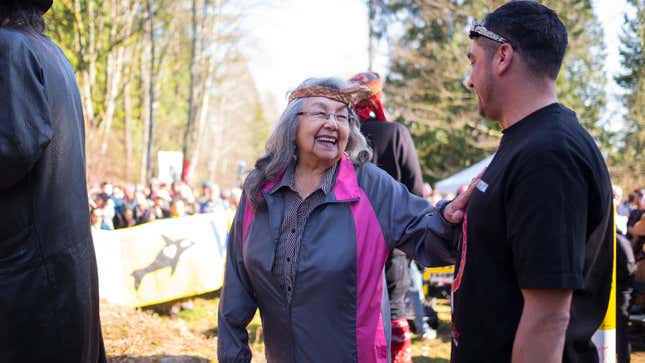 Will George (right) welcomes a visitor to the watch house with protestors from the March 10 march in the background.