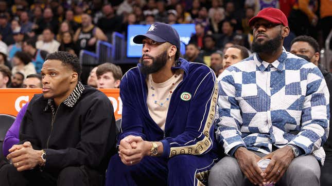 Russell Westbrook, Anthony Davis, and LeBron James of the Los Angeles Lakers watch from the bench during the first half of the NBA game against the Phoenix Suns.