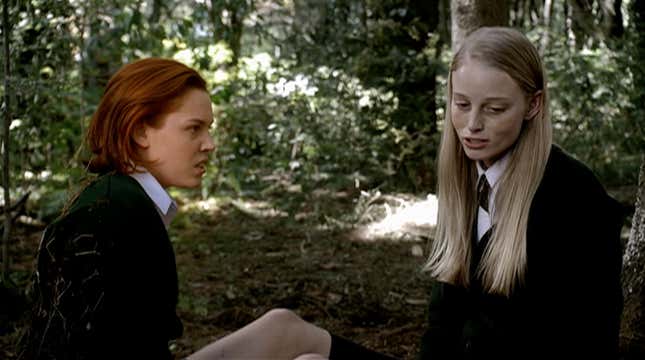 Two girls in boarding-school uniforms sit and talk in horror movie The Woods.