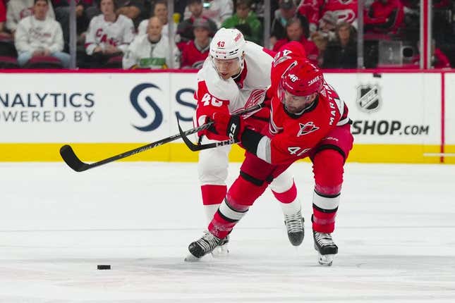 Apr 11, 2023; Raleigh, North Carolina, USA; Detroit Red Wings right wing Alex Chiasson (48) and Carolina Hurricanes left wing Jordan Martinook (48) battle for the puck during the first period at PNC Arena.