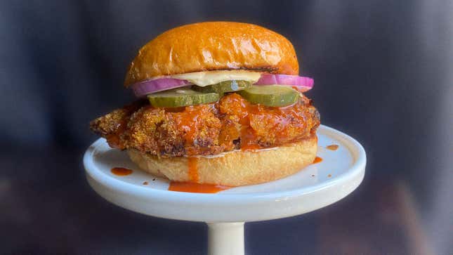 Ultimate Air-Fried Spicy Chicken Sandwich on white plate against black background