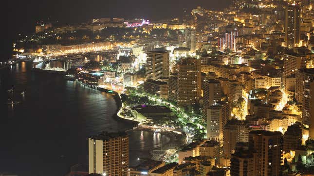 A photo of the Monaco harbor illuminated at night time. 