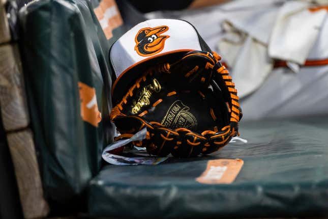 Jun 1, 2021; Baltimore, Maryland, USA; A Baltimore Orioles hat and glove are seen in the dugout during the fourth inning of the game between the Baltimore Orioles and the Minnesota Twins at Oriole Park at Camden Yards.