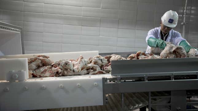 A worker processes cuts of beef.
