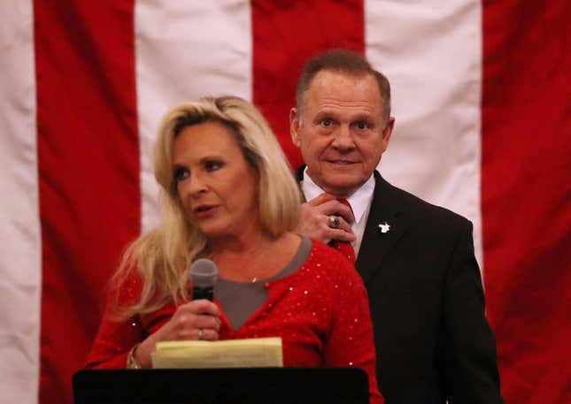 Roy Moore stands behind his wife Kayla Moore as she speaks during a campaign event at Jordan’s Activity Barn on December 11, 2017 in Midland City, Alabama.