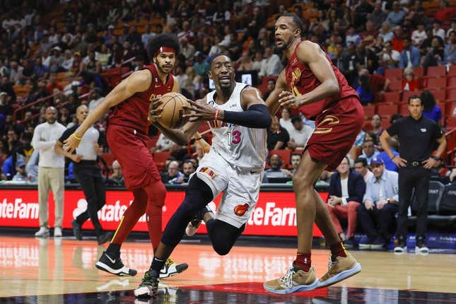 Mar 8, 2023; Miami, Florida, USA; Miami Heat center Bam Adebayo (13) drives to the basket ahead of Cleveland Cavaliers center Jarrett Allen (31) and forward Evan Mobley (4) during the first quarter at Miami-Dade Arena.