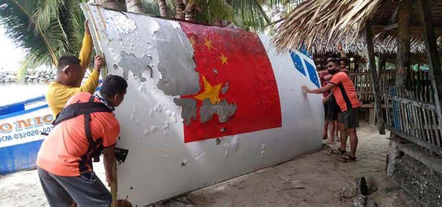 Members of the Philippine Coast Guard recovering a piece of suspected debris belonging to China’s Long March 5B rocket, which launched on July 24, 2022.