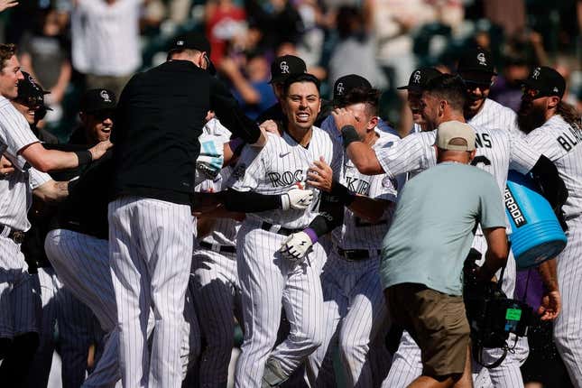 Jul 16, 2023; Denver, Colorado, USA; Colorado Rockies second baseman Alan Trejo (13) celebrates with teammates on a walk-off solo home run in the eleventh inning against the New York Yankees at Coors Field.