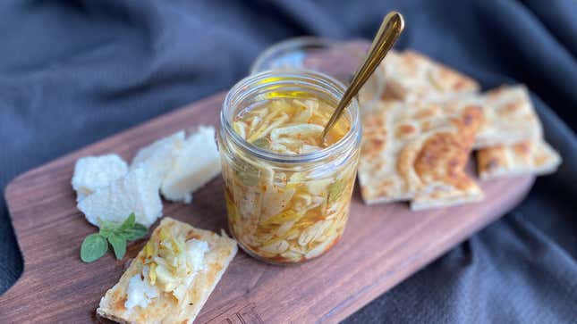 Lemon Pickled Garlic in jar on cutting board with bread and cheese