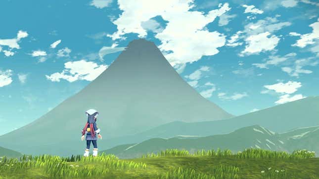 The female protagonist of Pokémon Legends: Arceus stands overlooking a field with a mountain in the distance.