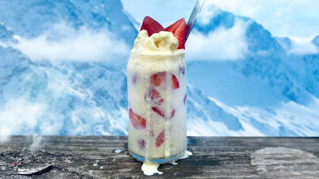 Strawberry Buttermilk Snowball in a glass on a wood surface in front of mountainous backdrop
