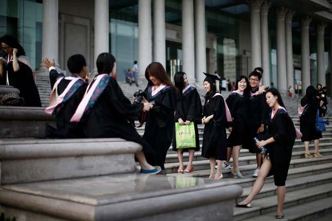Graduates stand on the steps in front of the academic building at Fudan University in Shanghai.