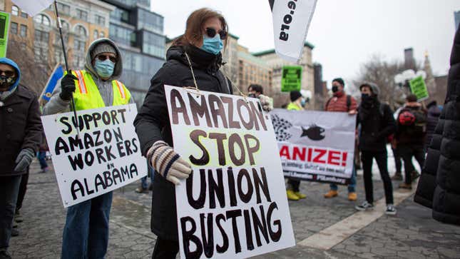 People hold placards during a protest in support of Amazon workers in Union Square, New York on February 20, 2021.