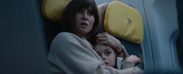 Nadja and her son Elias clinging to one another in fear as their plane is hijacked by a group of men.