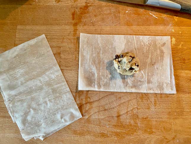 Yufkayı tereyağlı tarafı aşağı gelecek şekilde ters çevirin, hamuru ikiye bölün ve ortasına biraz kurabiye hamuru açın.
