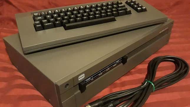 A NABU box with a keyboard and a adapter plug. 