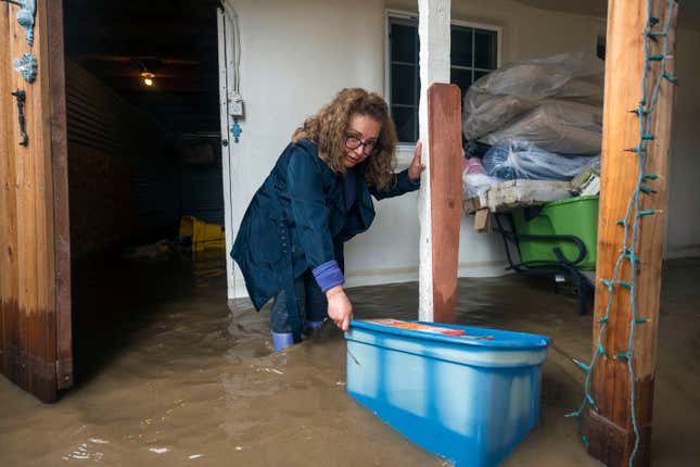 Photo of woman crouching in floodwaters