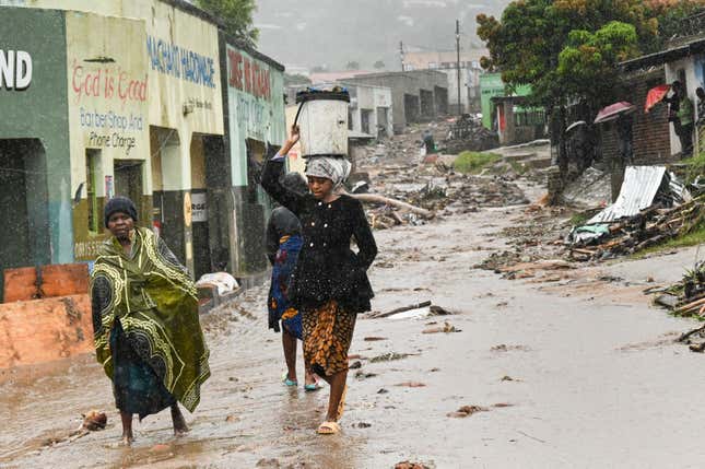 Women walk down a street in Blantyre after the storm.