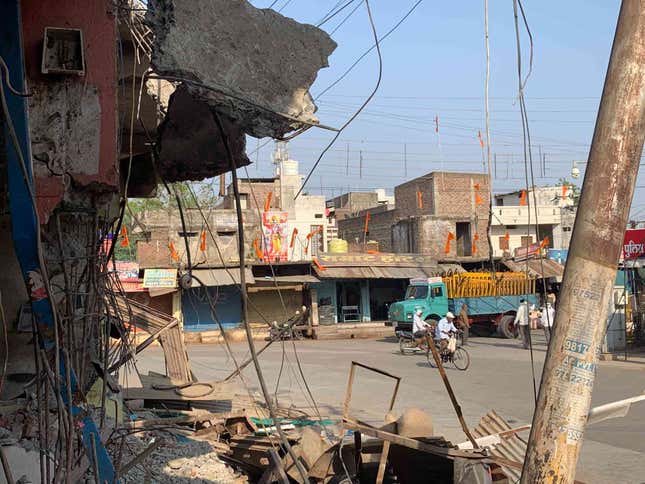 At Talab Chowk, a banner from the Ram Navami procession can still be seen amidst the rubble of demolished shops.