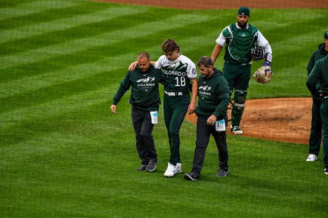 May 13, 2023; Denver, Colorado, USA; Colorado Rockies starting pitcher Ryan Feltner (18) is helped off the field by the medical staff after getting hit by a line drive by Philadelphia Phillies Nick Castellanos in the second inning at Coors Field.