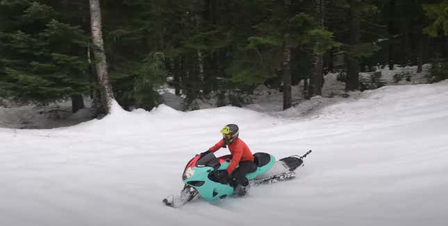 A man in a red jacket carves through the snow on a two-tone 2005 Suzuki Hayabusa snow bike