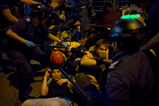 Protesters fall on the ground as they are chased by riot police in Mong Kok on Nov. 29, 2014.