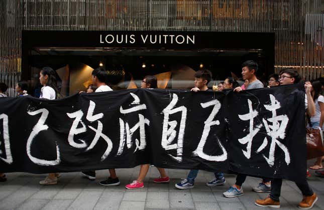 Protesters carry a banner which reads "We choose our own government" during a march at the financial Central district in Hong Kong September 24, 2014.