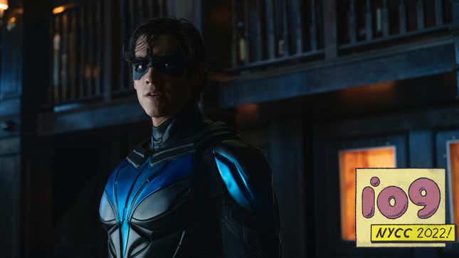 A front-lit Nightwing stand imposingly in a dark alley, an intense look on his face.