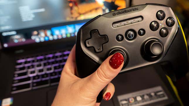 A photo of a gaming controller in front of a computer with a cloud gaming suite on it 