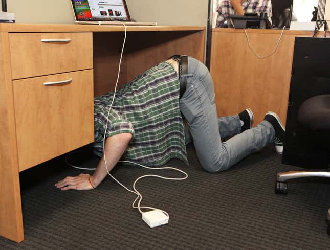 Image for article titled Area Man Crawling On Ground Like Pig To Plug Macbook Power Cord Behind Desk