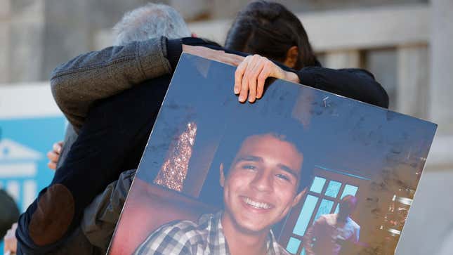 Photo of two people embracing and holding a large photo 