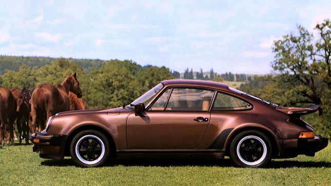 A photo of a brown Porsche 911 in a field of horses. 
