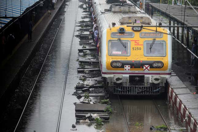 A Mumbai local train moves through a water-logged track on July 1, 2019.