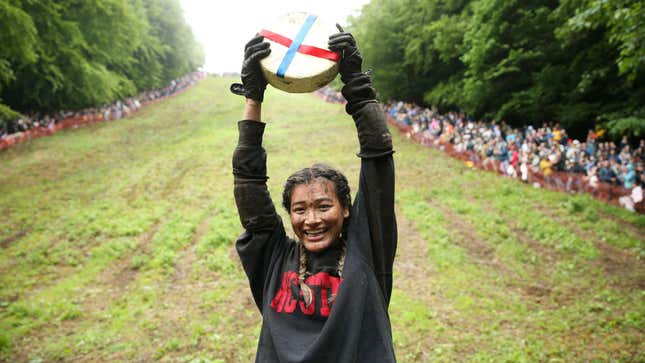 The winner of this year’s Cooper’s Hill Cheese-Rolling competition displays her prize.