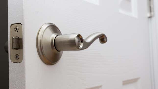 A photo of a white interior door with a silver lever-style handle.