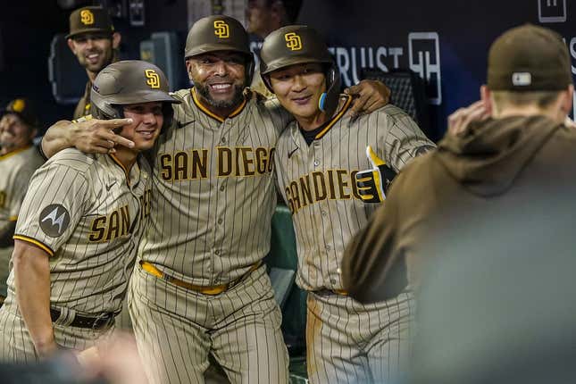 Apr 9, 2023; Cumberland, Georgia, USA; San Diego Padres second baseman Ha-Seong Kim (7) (right) gets a photo in the dugout with designated hitter Nelson Cruz (32) (center) and a bat boy after hitting a home run against the Atlanta Braves during the fifth inning at Truist Park.