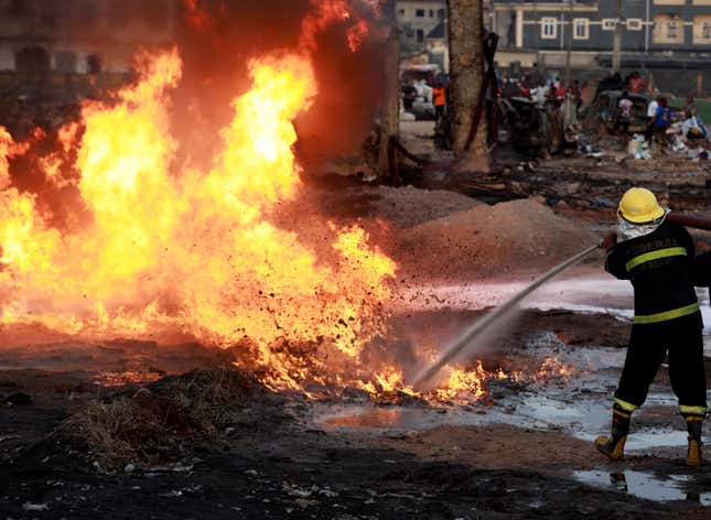 A firefighter battles to put out a ruptured pipeline fire burning at Abule-Ado in Lagos, Nigeria, Mar. 15, 2020.