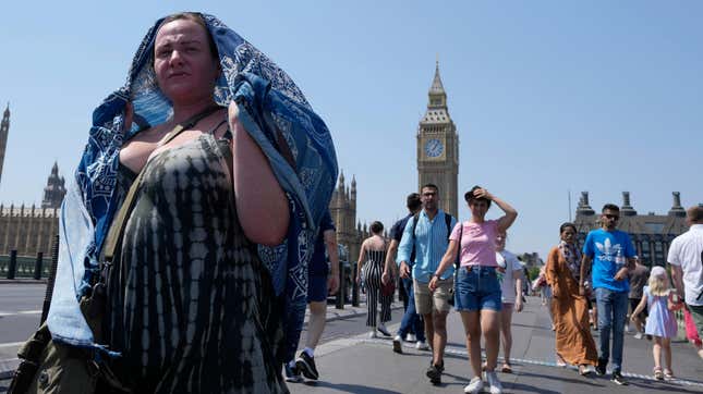 Pedestrians try to keep themselves cool in London on Tuesday.