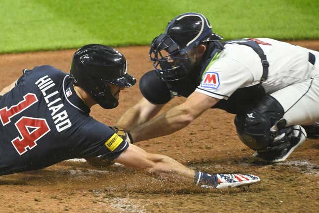 Jul 4, 2023; Cleveland, Ohio, USA; Cleveland Guardians catcher David Fry (12) tags out Atlanta Braves center fielder Sam Hilliard (14) in the tenth inning at Progressive Field.