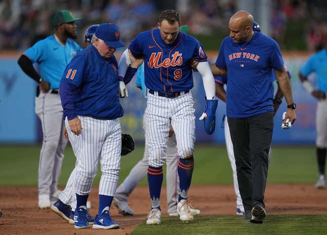 Mar 17, 2023; Port St. Lucie, Florida, USA;  New York Mets center fielder Brandon Nimmo (9) walks back to the dugout with the assistance of manager Buck Showalter (11) and a trainer in the fifth inning against the Miami Marlins at Clover Park.