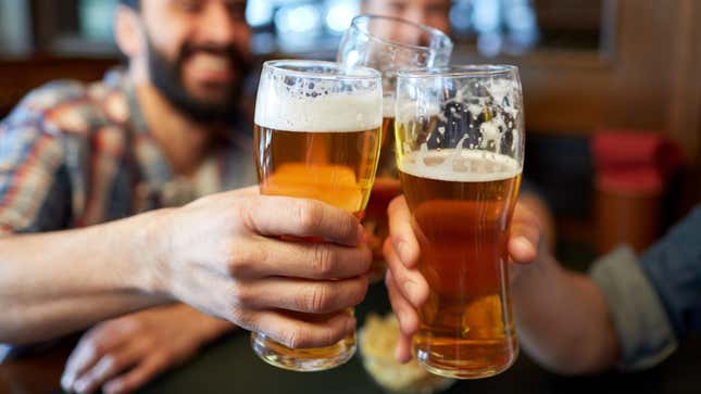 men clinking beer glasses together in a bar