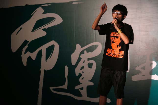 Hundreds of children joined students demanding greater democracy for Hong Kong on Friday, capping a week-long campaign that has seen a large cut-out depicting the territory's leader as the devil paraded through the city and calls for him to resign. The Chinese characters on the background read "Fate". REUTERS/Bobby Yip (CHINA - Tags: POLITICS EDUCATION CIVIL UNREST) - RTR47TQB