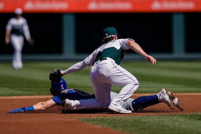Sep 13, 2023; Denver, Colorado, USA; Chicago Cubs second baseman Nico Hoerner (2) is tagged out attempting to steal second against Colorado Rockies second baseman Brendan Rodgers (7) in the first inning at Coors Field.