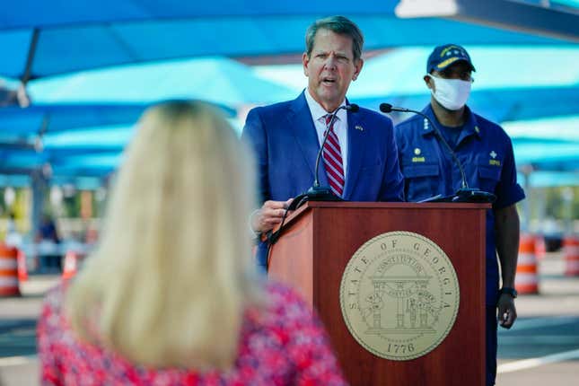 Georgia Governor Brian Kemp speaks as U.S. Surgeon General Jerome Adams looks on during a press conference announcing expanded statewide COVID testing on August 10, 2020 in Atlanta, Georgia. . 