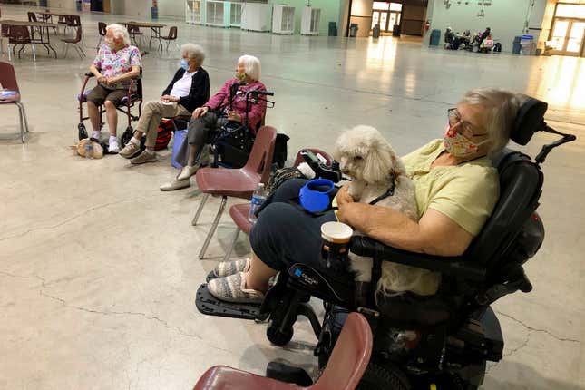 Patricia Fouts, 73, sits with her dog, Murphy, and other evacuated residents of a senior living home in an evacuation center at the Oregon State Fairgrounds in Salem, Oregon, on Tuesday, Sept. 8, 2020.