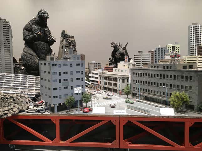 The Godzilla in the background in the center is the current Godzilla: King of the Monsters design. Also, “please do not touch.”