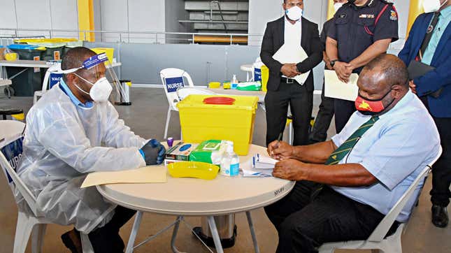Papua New Guinea’s Prime Minister James Marape (R) preparing to receive a dose of the AstraZeneca Covid-19 vaccine in Port Moresby on March 30, 2021.